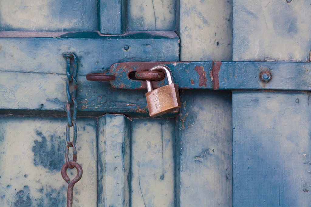 Canva - Gold Padlock Locking Door